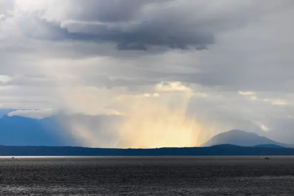 嵐のような雲と山で海を渡る大きな嵐 ストックフォト