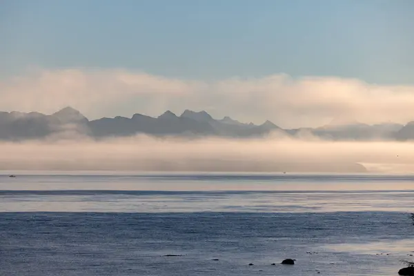 Spokojne Jezioro Pokryte Mgłą Majestatycznych Gór Tle Tworząc Wspaniały Krajobraz Zdjęcia Stockowe bez tantiem