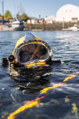 Commercial diver in helmet gazes at camera closeup clipart