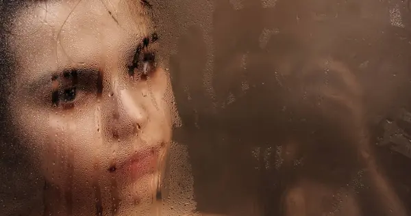 stock image Woman touching steamy shower glass with hand closeup