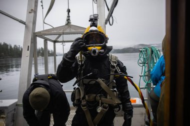 Commercial diver prepared for deep water entry closeup clipart