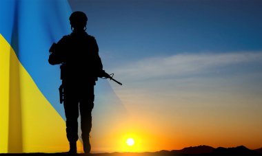 Silhouette of a walking soldier against the sunset and Ukrainian Flag. EPS10 vector
