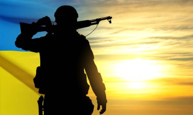 Silhouette of soldier with Ukraine flag against the sunset. Armed forces of Ukraine concept. EPS10 vector