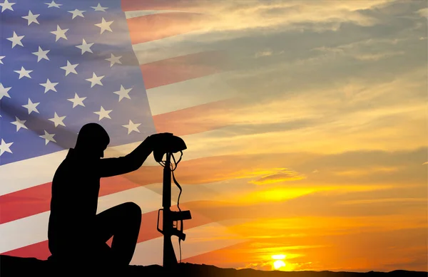 Silhouette of soldier kneeling down on a background of sunset and USA flag. Greeting card for Independence Day, Veteran Day, Memorial Day