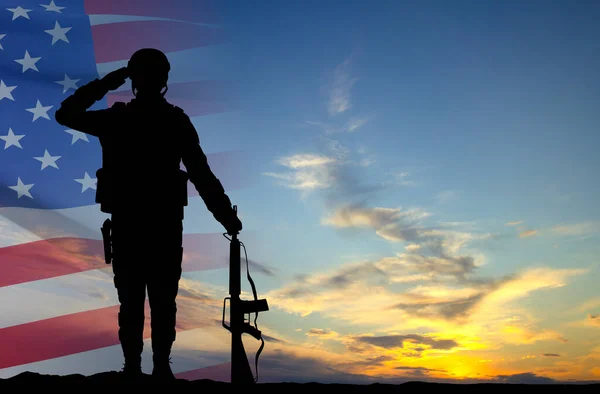 Silhouette of a soldier with USA flag against the sunset. Greeting card for Veterans Day, Memorial Day, Independence Day