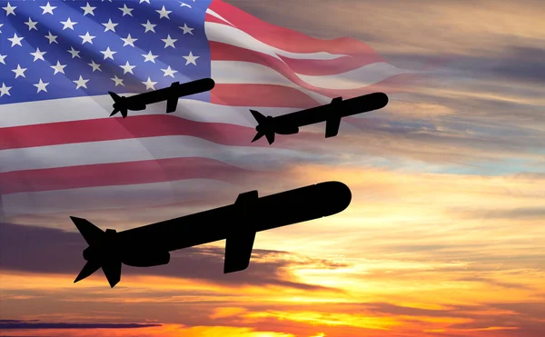 Silhouettes of Tomahawk cruise missiles with USA flag against the sunset
