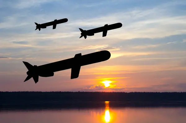 Silhouettes of Tomahawk cruise missiles against the sunset