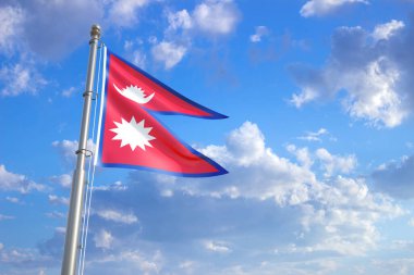 Mavi bulutlu gökyüzüne karşı rüzgarda dalgalanan Nepal bayrağı