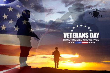 Gün batımına karşı Amerikan bayrağı taşıyan bir askerin siluetleri. Gaziler Günü. Hizmet Edenleri Onurlandırmak