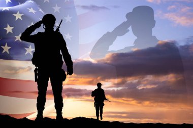 Gün batımına karşı Amerikan bayrağı taşıyan bir askerin siluetleri. Gaziler Günü. Hizmet Edenleri Onurlandırmak