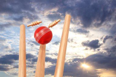 Cricket ball hitting wicket stumps against blue sky background. 3d-rendering clipart