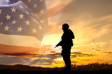 Gün batımına karşı Amerikan bayrağı taşıyan bir askerin silueti. Gaziler Günü, Anma Günü konsepti