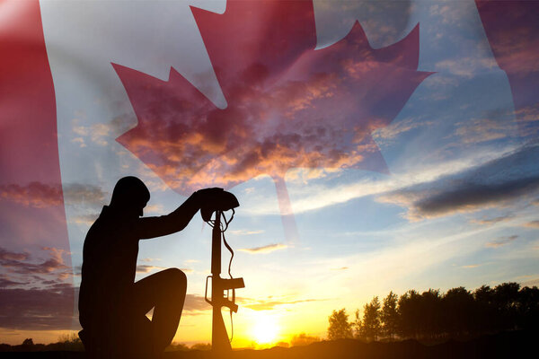 Силуэт солдата, стоящего на коленях с канадским флагом на закате. Открытки на День Поппи, День памяти