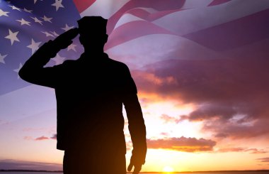 Gün batımına karşı Amerikan bayrağı taşıyan bir askerin silueti. Gaziler, Anma Günü konsepti