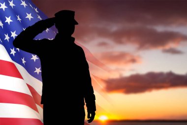 Gün batımına karşı Amerikan bayrağı taşıyan bir askerin silueti. EPS10 vektörü