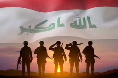 Gün batımında Irak bayrağı taşıyan bir askerin siluetleri. Ulusal Tatil Konsepti. Askeri geçmiş