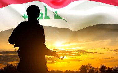 Gün batımına karşı Irak bayrağı taşıyan bir askerin silueti. Ulusal Tatil Konsepti. Askeri geçmiş