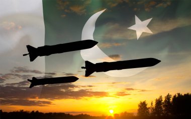 Pakistan bayrağıyla gün batımına karşı füzelerin silueti