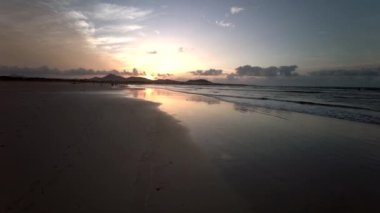 Famara Sahili 'nde güzel bir gün batımı. Lanzarote Kanarya Adaları Caleta de Famara, Famara Sahili Rüzgar sörfü ve akşam güneşinde sörf plajı