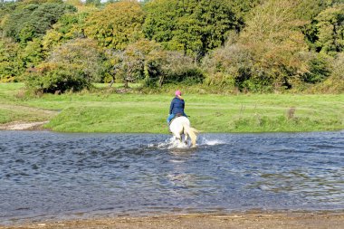Ewenny Ogmore Kalesi 'ni geçen atlılar. Ogmore by Sea, Glamorgan, Wales, İngiltere - 15 Ekim 2022