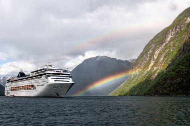 Rainbow over MSC Lirica Cruise ship in Norwegian Fjords - Geiranger fjord - Hellesylt, Sunnylvsfjord, Norway, Scandinavia. Travel destination Norway. 02.07.2012