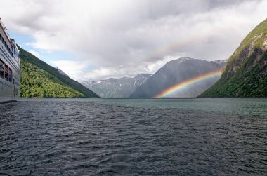 Geirangerfjord üzerinde güzel bir gökkuşağı, Norveç 'in Geiranger köyünün yakınında yer alıyor..