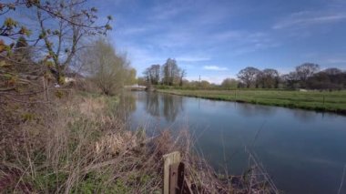 İngiltere 'nin güneyindeki Salisbury yakınlarındaki Yukarı Woodford' da Avon Nehri (Bristol Avon) ile İngiliz bahar manzarası