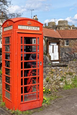 Güneşli bir günde İngiltere, Somerset 'te Nunney Köyü' nde eski bir İngiliz telefon çizmesi - 8 Nisan 2023
