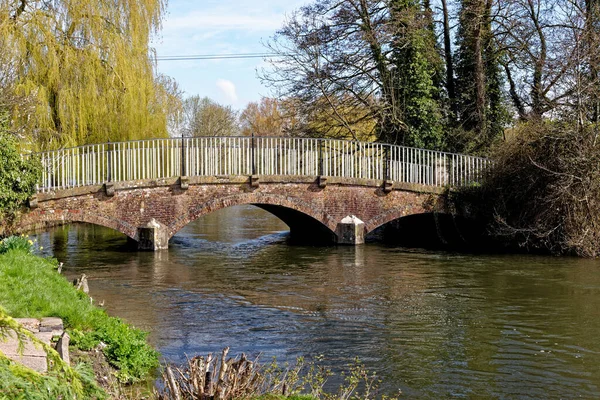 stock image Red brick arched bridge with metal railing over the Avon river (Bristol Avon) at Upper Woodford near Salisbury in Southern England, United Kingdom