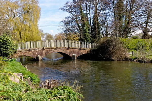 stock image Red brick arched bridge with metal railing over the Avon river (Bristol Avon) at Upper Woodford near Salisbury in Southern England, United Kingdom