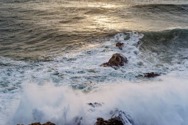 Portekiz 'in Nazare kasabasındaki Atlantik Okyanusu' na bakın. Büyük bir dalga sahil boyunca bir kayaya çarpıyor. Dünyanın en büyük dalgaları Nazare, Leiria Bölgesi, Portekiz 'de.