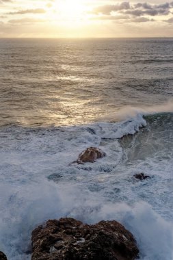 Portekiz 'in Nazare kasabasındaki Atlantik Okyanusu' na bakın. Büyük bir dalga sahil boyunca bir kayaya çarpıyor. Dünyanın en büyük dalgaları Nazare, Leiria Bölgesi, Portekiz 'de.