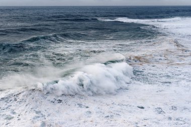Portekiz 'in Nazare kasabasındaki Atlantik Okyanusu' na bakın. Büyük bir dalga sahil boyunca bir kayaya çarpıyor. Dünyanın en büyük dalgaları Nazare, Leiria Bölgesi, Portekiz 'de.
