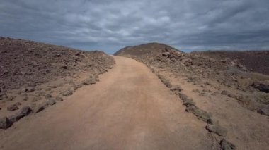 Lobos Adası 'nın volkanik manzarası gibi tipik uydudan geçen patika. Lobos Adası - Fuerteventura, Kanarya Adaları, İspanya - 24.09.2023