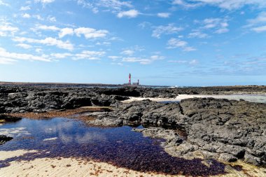 Playa de los Charcos plajı ve Toston Deniz Feneri 'nin doğal gel-git havuzları Fuerteventura, Kanarya Adaları, İspanya' daki Los Charcos ya da Los Laguitos Sahili 'nin doğal deniz havuzu. 24.09.2023