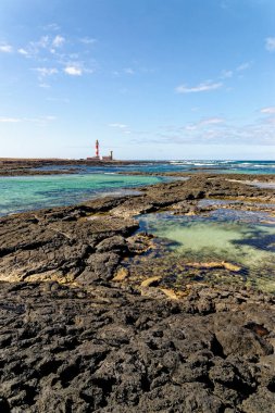 Playa de los Charcos plajı ve Toston Deniz Feneri 'nin doğal gel-git havuzları Fuerteventura, Kanarya Adaları, İspanya' daki Los Charcos ya da Los Laguitos Sahili 'nin doğal deniz havuzu. 24.09.2023