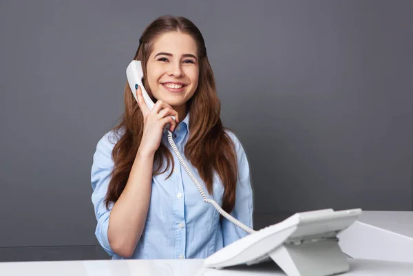 Piękna Recepcjonistka Uśmiechająca Się Rozmawiająca Przez Telefon — Zdjęcie stockowe