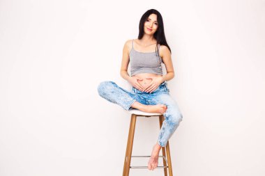 Bar taburesinde poz veren hamile güzel bir kadının vücut portresi..