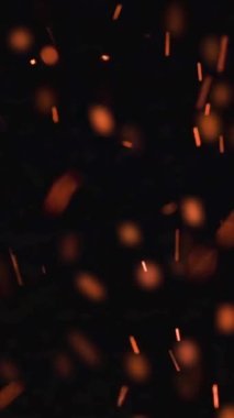 Aşırı yavaş çekim yüksek ateş hızı ve siyah zemin üzerinde parlayan kül parçacıkları - makara ve hikaye için dikey video