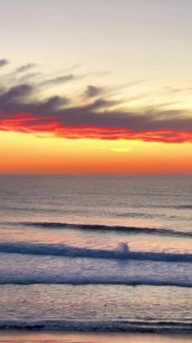 Sagres, Portekiz 'in kayalıklarını ve kıyılarını yıkayan okyanus dalgalarında sörfçülerin dikey çekimi