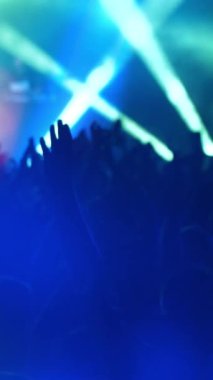 Gençler müzik konserini kutluyorlar. Hayranlar zıplar ve ellerini kaldırır. Heyecanlı hayranlar alkış tutuyor. Makara ve öykü için dikey video.