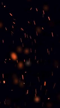 Aşırı yavaş çekim yüksek ateş hızı ve siyah zemin üzerinde parlayan kül parçacıkları - makara ve hikaye için dikey video