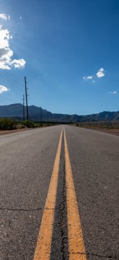 Güneşli bir yaz gününde, parlak günbatımında ufka giden boş uzun Nevada dağ yolu. makara ve öykünüz için dikey resim