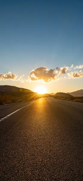 Güneşli bir yaz gününde, parlak günbatımında ufka giden boş uzun Nevada dağ yolu. makara ve öykünüz için dikey resim