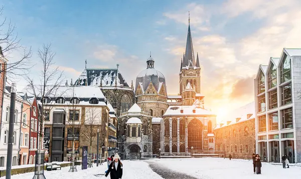 アーヘン ドイツのカール皇帝の有名な巨大なゴシック様式の大聖堂は 冬のシーズンに青空と日差しの背景に対してカツホフで雪が降ります ロイヤリティフリーのストック画像