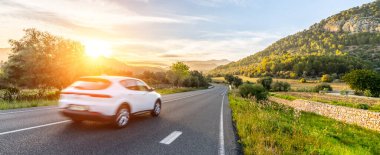 Günbatımında İspanya 'da kiralık bir araba. Geniş açılı panorama çekimi.