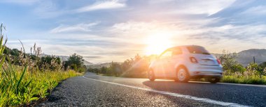 Günbatımında İspanya 'da kiralık bir araba. Geniş açılı panorama çekimi.