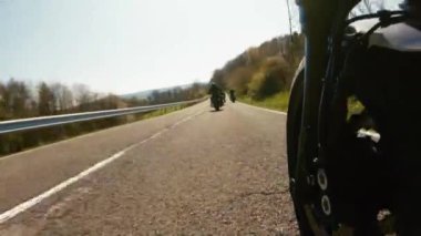 Orman yolunda motosiklet sürerken. Arkadaşlar boş yolda eğleniyor..