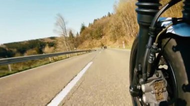 Orman yolunda motosiklet sürerken. Arkadaşlar boş yolda eğleniyor..