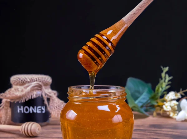蜂蜜勺慢吞吞地从盛满蜂蜜的罐子里出来 蜂蜜含有多种营养物质 抗氧化剂 改善心脏健康 伤口护理 提供抗抑郁和抗焦虑的功效 — 图库照片